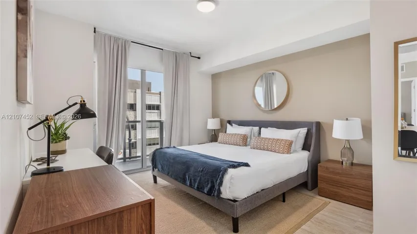 Bedroom featuring a sliding glass door providing natural light and access to a private balcony