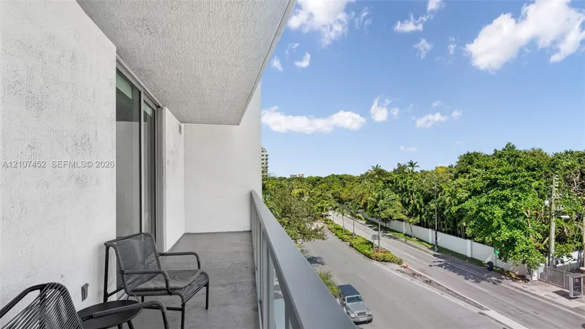Private covered balcony featuring concrete flooring, stucco walls, and a metal railing