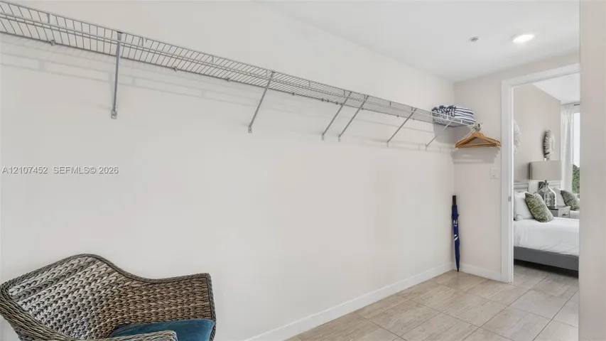 Large walk-in closet featuring wall-to-wall wire shelving and tile flooring