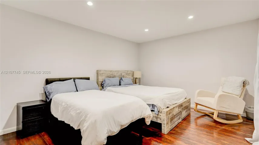 Interior space featuring neutral-toned walls, recessed lighting, and dark-toned wood-finish flooring