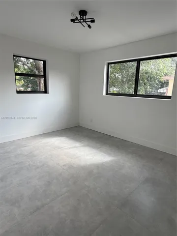Neutral-toned large-format tile flooring, matte black window frames, and contemporary geometric ceiling lighting
