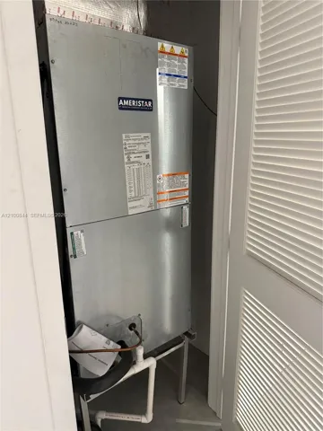 Ameristar HVAC air handler unit mounted on a metal support frame with connected PVC drain piping and louvered closet door access