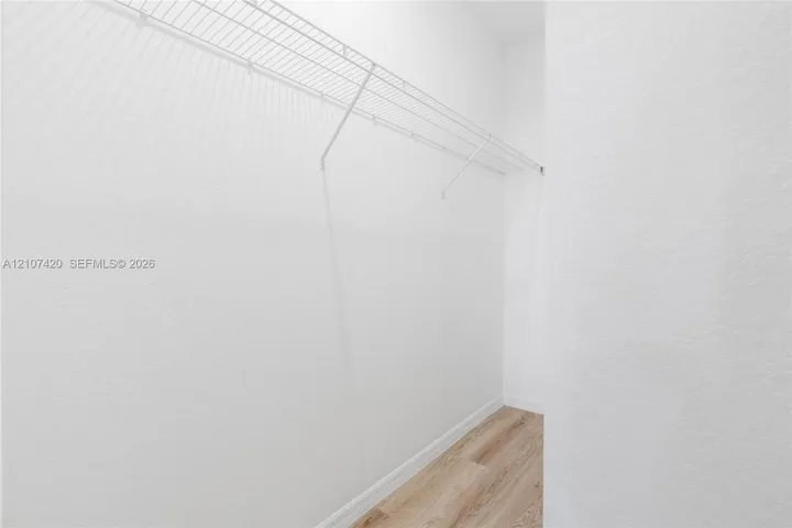 Storage space featuring wood-finish flooring and integrated wire shelving
