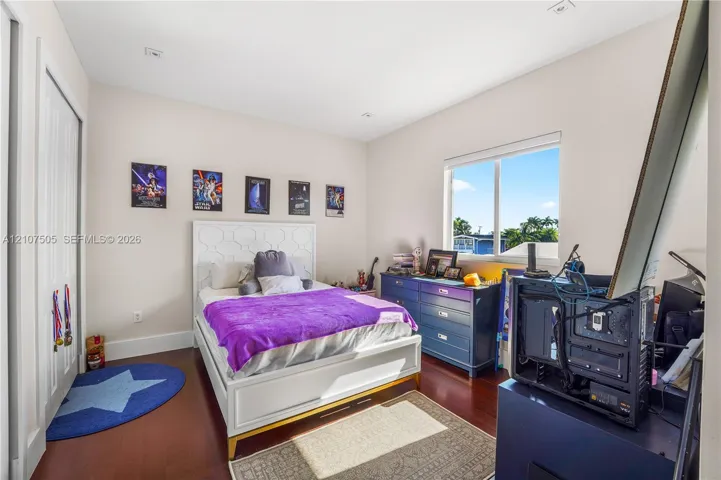 Room featuring wood-finish flooring, recessed lighting, and a single-pane window