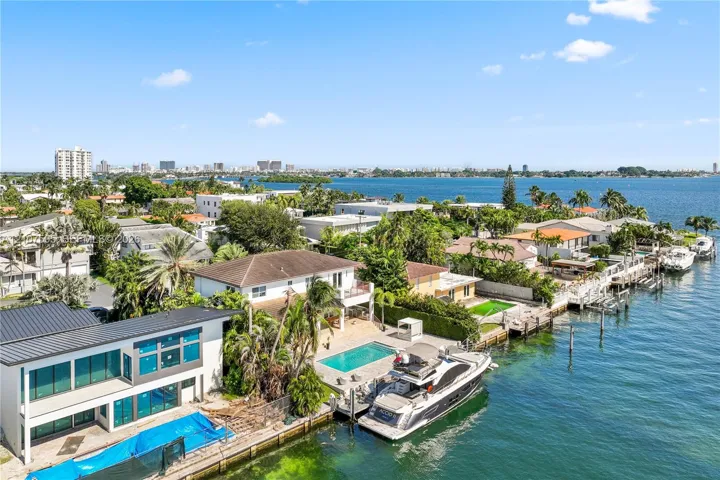 Waterfront property featuring a private boat dock, rectangular in-ground swimming pool, and multi-level exterior structure