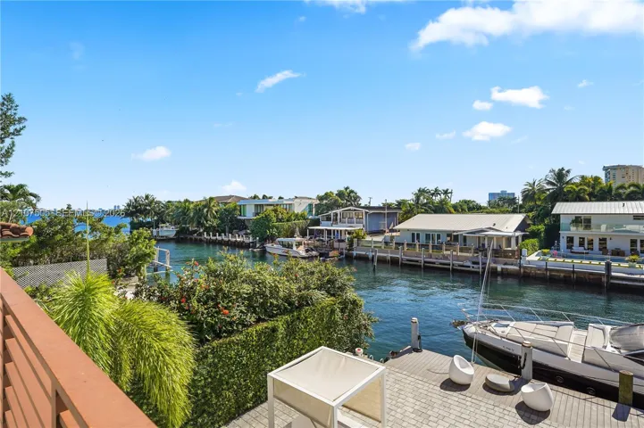 Waterfront property featuring a private paved dock, canal access, and mature landscaping