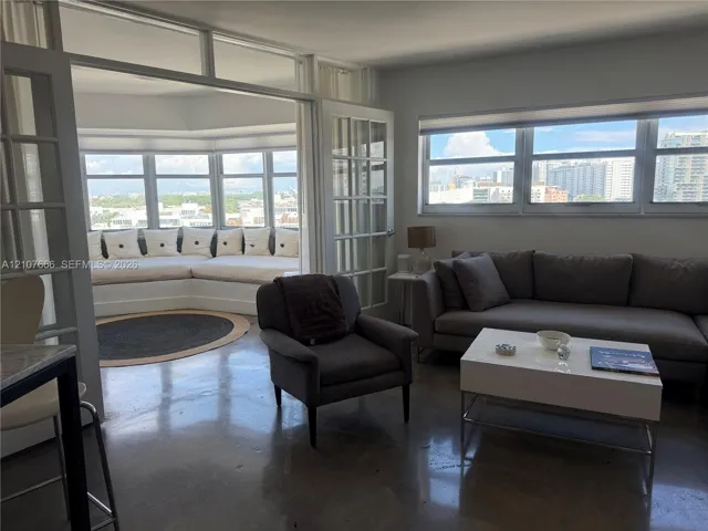 Polished concrete flooring, expansive wrap-around windows, built-in window seating, and glass-paned French doors