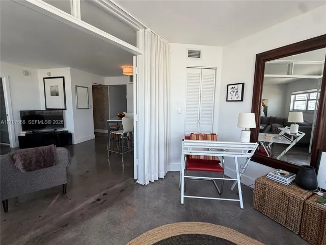 Polished concrete flooring, floor-to-ceiling glass panel partitions, and louvered closet doors