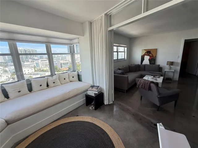 Built-in window seating, floor-to-ceiling windows, polished concrete flooring, and sliding glass panel partitions