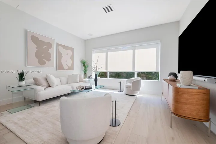 Light-filled interior featuring expansive picture windows, neutral walls, and light wood-finish flooring