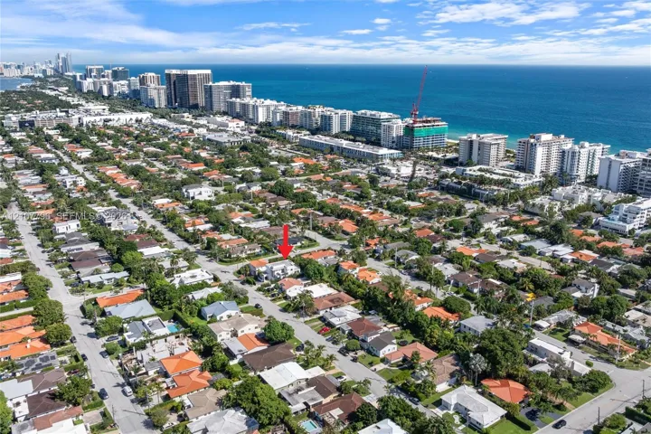 Aerial perspective of a residential property situated in a coastal area, featuring mature landscaping and proximity to the Atlantic Ocean