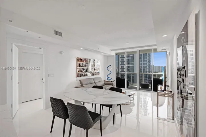 Open-concept living space featuring high-gloss tile flooring, recessed lighting, and floor-to-ceiling glass sliding doors