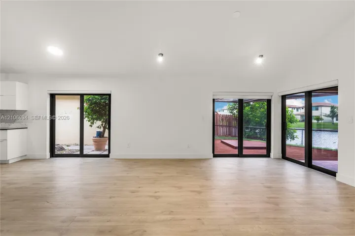 Open-concept interior, recessed lighting multiple sliding glass doors providing outdoor access