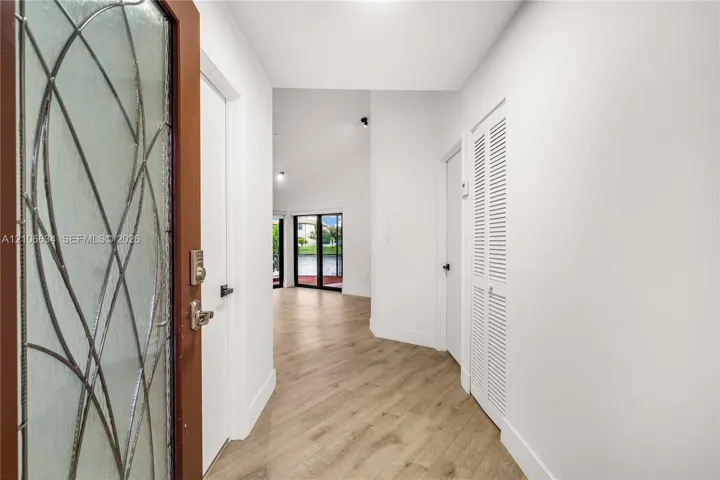 Entryway featuring a front door with decorative glass - white door to the right is the primary bedroom entrance