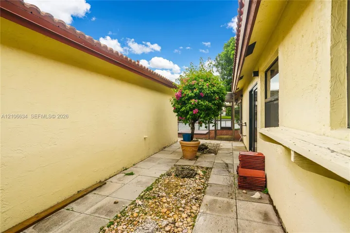 Exterior side yard entrance with paved walkway