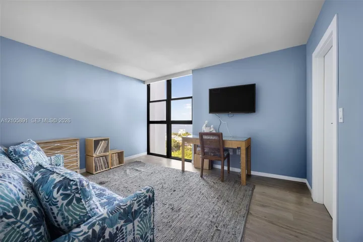 Floor-to-ceiling windows with black framing and wood-finish flooring