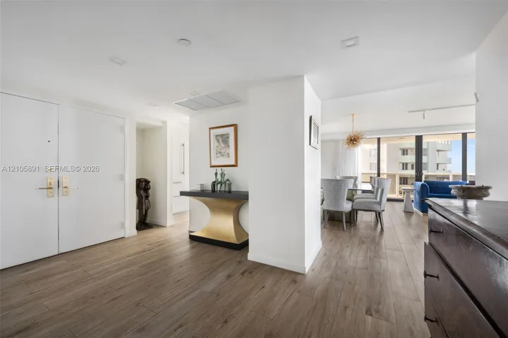 Interior space featuring wood-finish flooring, recessed ceiling lighting, and floor-to-ceiling glass sliding doors with access to an exterior balcony