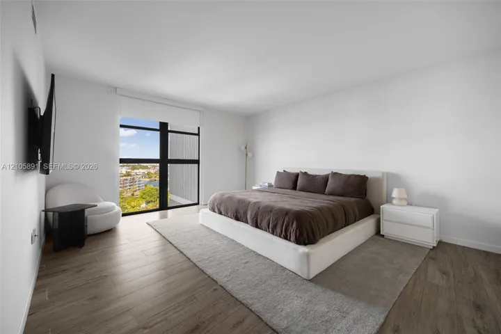 Floor-to-ceiling windows with dark framing, wood-finish flooring, and high ceilings
