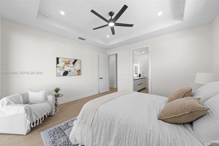Tray ceiling with recessed lighting, integrated matte black ceiling fan, wood-finish flooring, and recessed LED ceiling lights