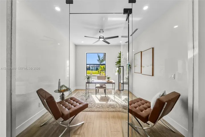 Glass-enclosed room featuring wood-finish flooring, recessed lighting, and a modern ceiling fan