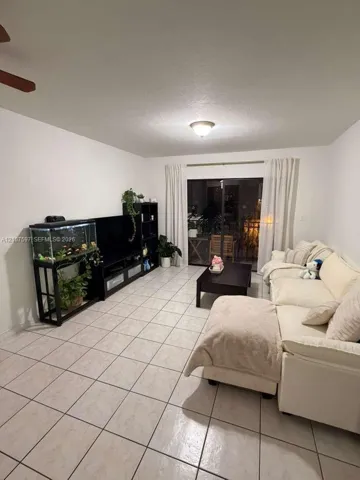 Ceramic tile flooring, neutral wall finishes, ceiling-mounted light fixture, ceiling fan, and sliding glass door