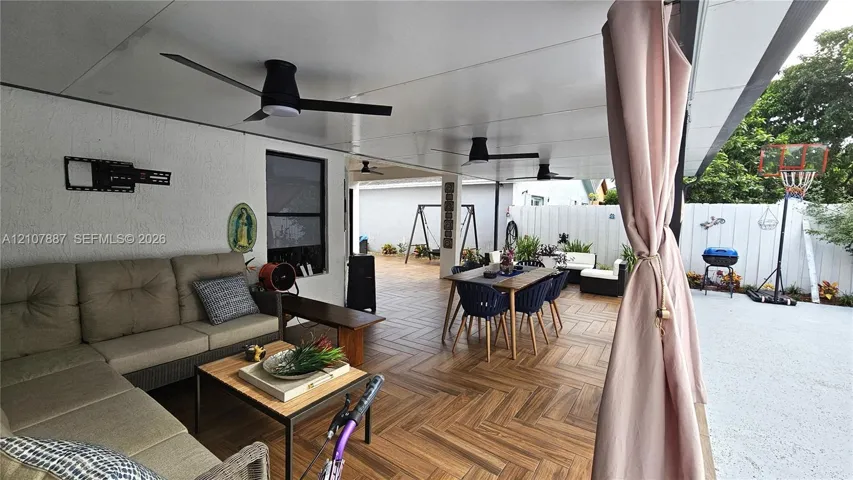 Covered outdoor patio featuring herringbone-patterned wood-finish flooring and multiple overhead ceiling fans