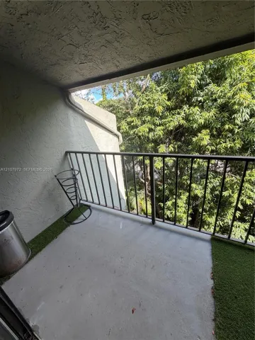 Covered balcony featuring concrete flooring and a metal railing