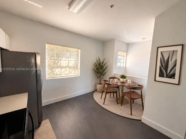 Wood-finish flooring, dual windows with roller shades, and integrated kitchen cabinetry