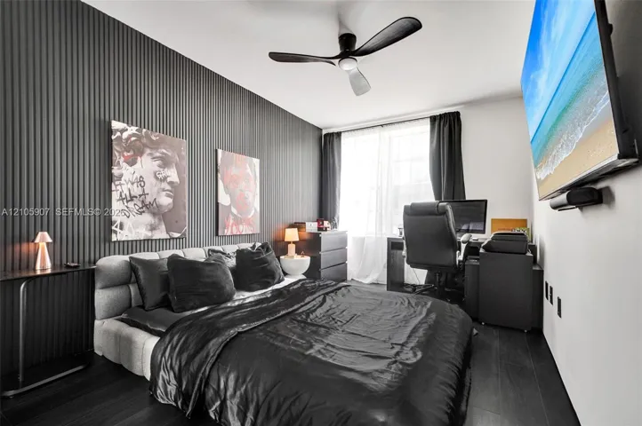Vertical-slat feature wall, dark-toned flooring, and three-blade ceiling fan