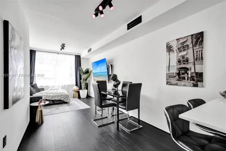 Dark wood-finish flooring, adjustable track lighting, and crisp white wall finishes
