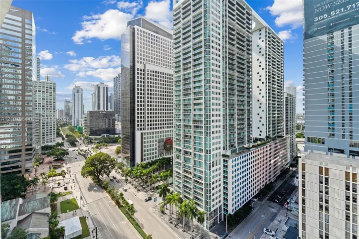 High-rise building featuring a glass facade, private balconies, and an urban cityscape setting