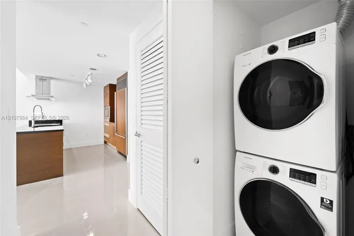 Stacked laundry unit featuring white front-load appliances