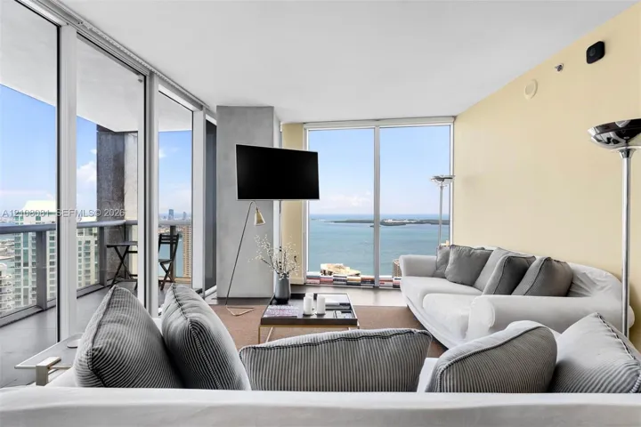 Floor-to-ceiling glass windows, private balcony, and polished concrete flooring