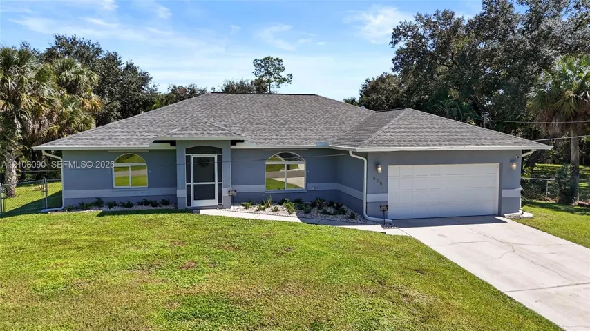 Single-story residence featuring a hipped roof, dual arched windows, attached two-car garage, and a covered entryway