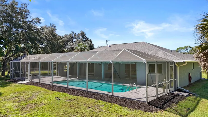 Screen-enclosed swimming pool with a concrete patio, tile roof, and exterior stucco siding