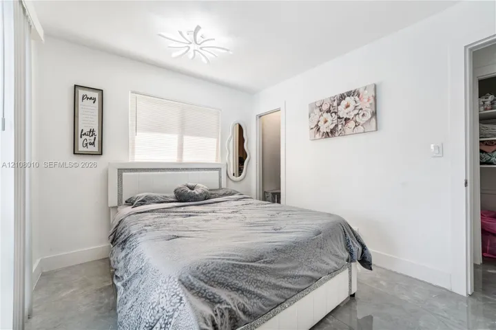 Neutral-toned stone-finish tile flooring, recessed ceiling lighting with a modern multi-point design, and a walk-in closet