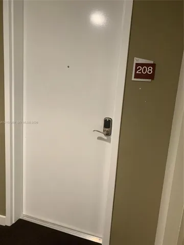 Entry door featuring a white finish, integrated metal deadbolt with electronic keypad access, and a centered peephole