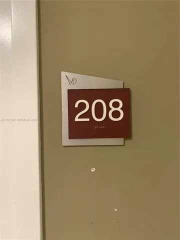 Brushed metal plaque featuring white numerical signage and integrated tactile characters