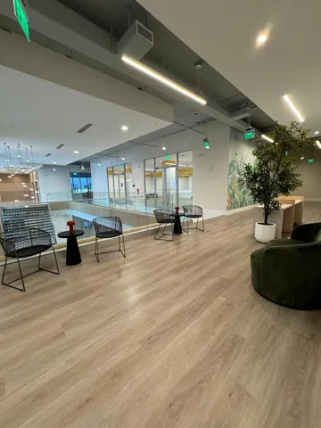Open floor plan featuring wood-finish flooring, industrial-style exposed ceiling, glass panel railings, and recessed lighting