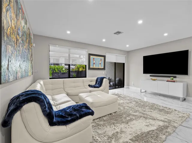 Large-format tile flooring, recessed lighting, and expansive sliding glass doors