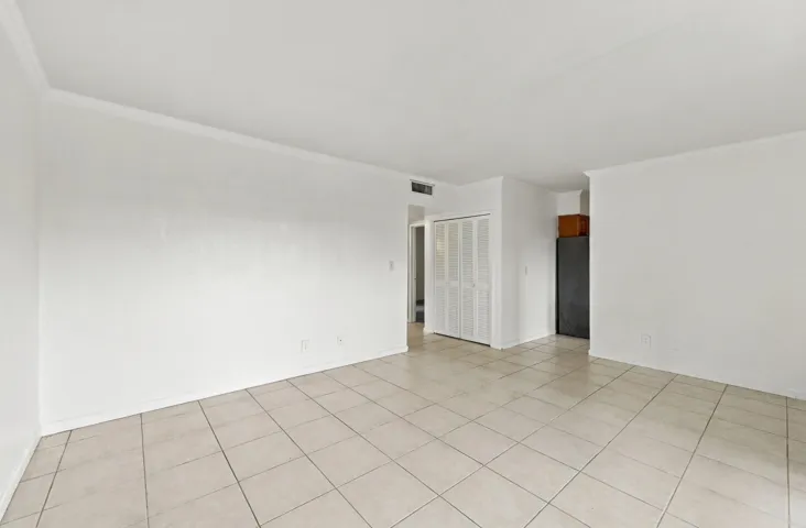 Neutral-toned tile flooring, white wall finishes, and bi-fold closet doors