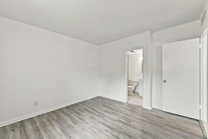 Interior space featuring wood-finish flooring, white walls, and a solid-core interior door
