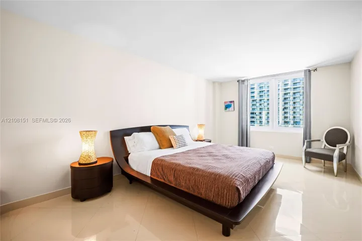 Neutral-toned tile flooring, high ceilings, and large windows providing natural illumination