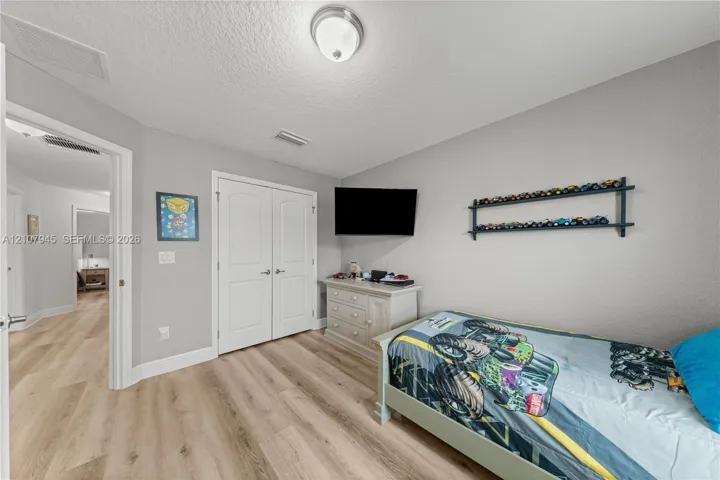 Wood-finish flooring, double-panel interior closet doors, and flush-mount ceiling lighting