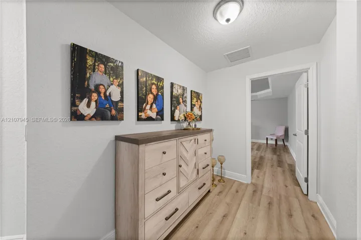 Interior space featuring wood-finish flooring, neutral wall tones, and a flush-mount ceiling light fixture