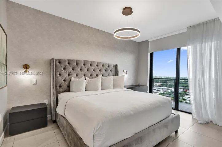 Textured feature wall, modern circular LED pendant lighting, wall-mounted globe sconces, large-format tile flooring, and floor-to-ceiling glass doors opening to a balcony