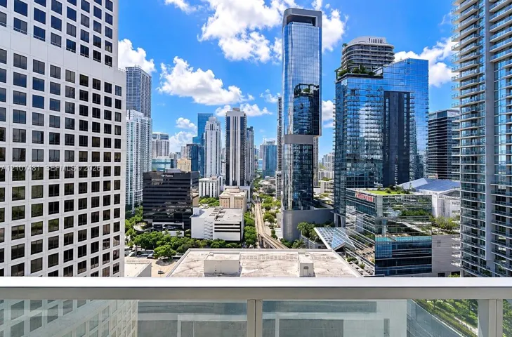 Balcony featuring glass panel railing and panoramic metropolitan skyline scenery