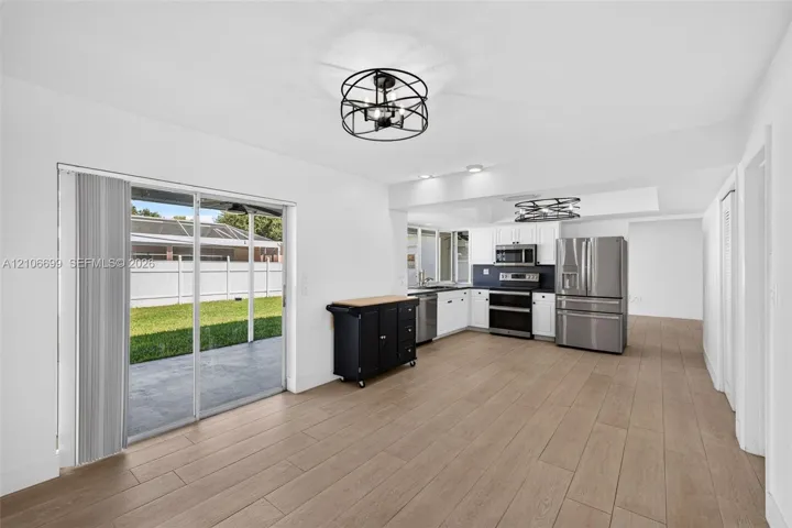 Open concept kitchen w/ updated plank wood look tile, stainless appliances approx 2020