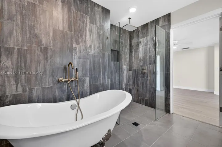 Primary bathroom w/ door to backyard. Separate tub & shower