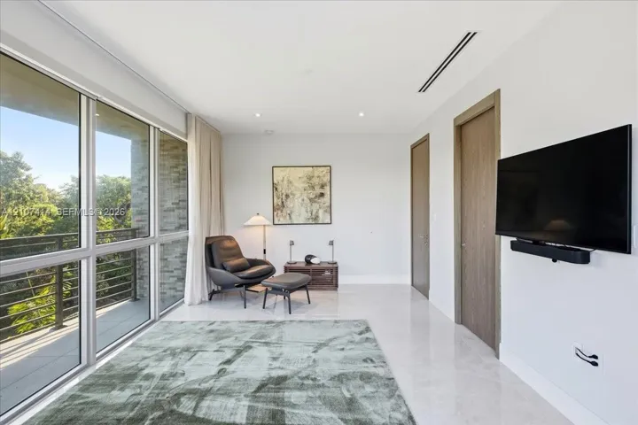 Floor-to-ceiling glass windows, stone flooring, wood-finish interior doors, and a recessed linear ceiling light fixture
